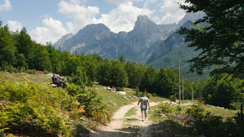 Cyclist hiking with bike Albanian Alps Theth to Valbona trail rocky path